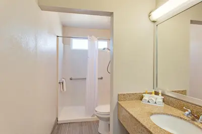 a bathroom with a toilet and a sink and a shower at Days Inn by Wyndham Chowchilla Gateway to Yosemite in Chowchilla