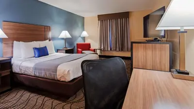 a hotel room with a bed and a chair at Best Western Plus Heritage Inn in Stockton