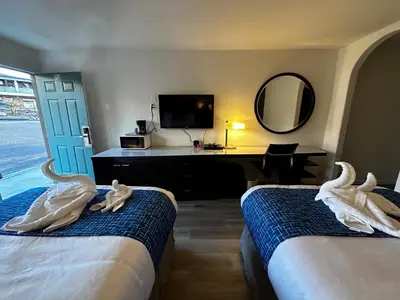two swans sitting on the beds in a hotel room at Sierra Inn in San Andreas