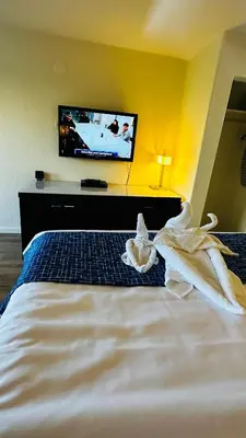a bedroom with a bed with a tv on the wall at Sierra Inn in San Andreas