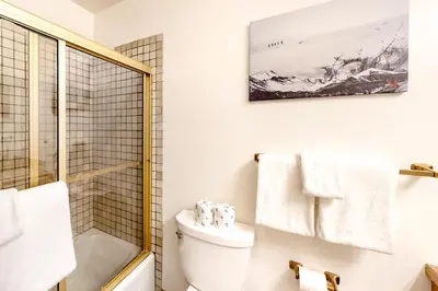 a white bathroom with a toilet and a shower at Mammoth Pines 11 in Mammoth Lakes
