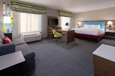 a hotel room with a bed and a couch at Hampton Inn Visalia in Visalia