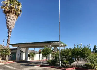 a gas station with a palm tree in front of it at Sunrise Inn in Turlock