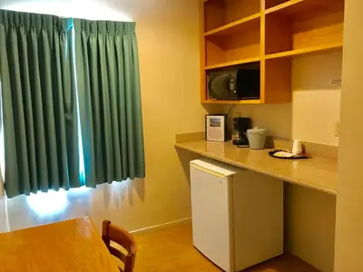 a kitchen with a green curtain and a refrigerator at Sunrise Inn in Turlock