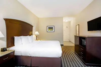 a hotel room with a bed and a flat screen tv at La Quinta by Wyndham Fowler in Fowler