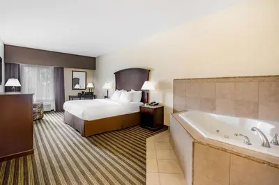 a hotel room with a bed and a bath tub at La Quinta by Wyndham Fowler in Fowler