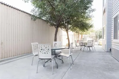 a patio with a table and chairs and a tree at Microtel Inn & Suites Modesto in Ceres