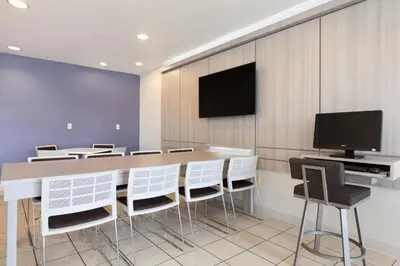 a conference room with a table and a television on a wall at Microtel Inn & Suites Modesto in Ceres