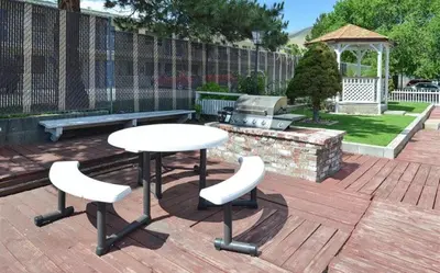 a table and two chairs on a deck with a grill at Americas Best Value Inn - Carson City in Carson City