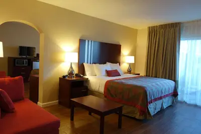 a hotel room with a bed and a couch at Ramada by Wyndham Sacramento in Sacramento