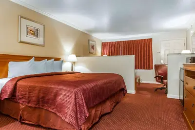 a hotel room with a bed and a chair at Quality Inn & Suites Gilroy in Gilroy