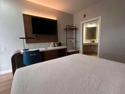 a bedroom with a bed and a desk with a television at SureStay by Best Western Morgan Hill in Morgan Hill