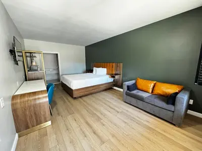 a small bedroom with a bed and a couch at SureStay by Best Western Morgan Hill in Morgan Hill