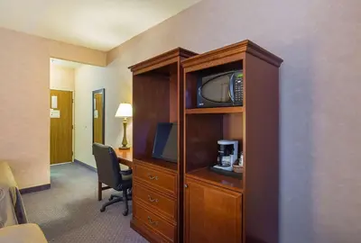 a hotel room with a desk and a tv in a cabinet at Quality Inn Fresno Yosemite Airport in Fresno