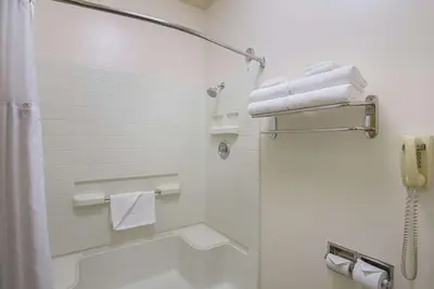 a bathroom with a shower and a toilet with towels at Quality Inn Fresno Yosemite Airport in Fresno