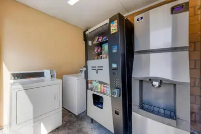 a kitchen with a refrigerator and a washer and dryer at Rodeway Inn at Nevada State Capitol in Carson City