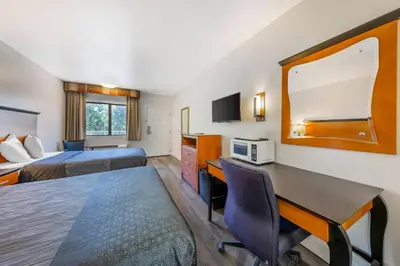 a hotel room with two beds and a desk at Rodeway Inn at Nevada State Capitol in Carson City