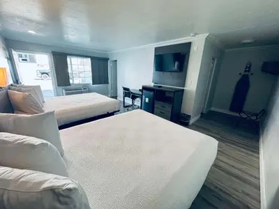 a hotel room with two beds and a flat screen tv at SureStay by Best Western Fresno Central in Fresno