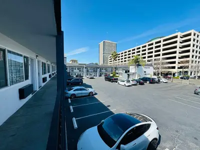 a white car parked in a parking lot next to a building at SureStay by Best Western Fresno Central in Fresno