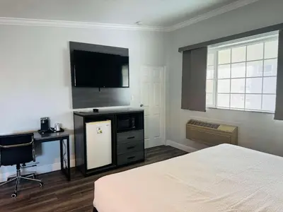 a bedroom with a bed and a flat screen tv at SureStay by Best Western Fresno Central in Fresno
