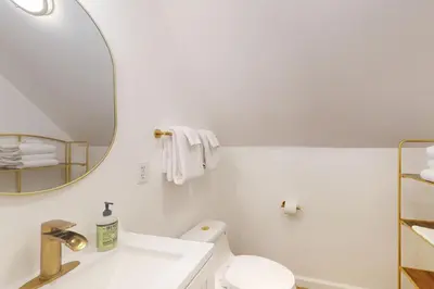 a white bathroom with a sink and a mirror at Deaver's Place in Shaver Lake