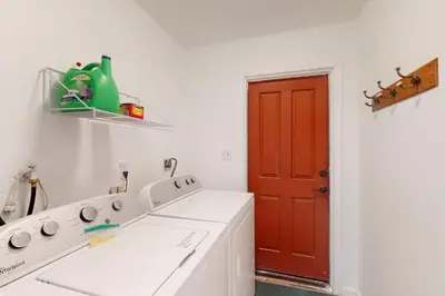 a kitchen with a washing machine and a red door at Deaver's Place in Shaver Lake