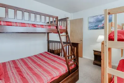 a bedroom with two bunk beds and a desk at Eagle's Landing Condo 68 in Lakeshore