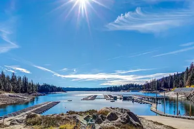 a river with a dock and the sun in the sky at Eagle's Landing Condo 68 in Lakeshore