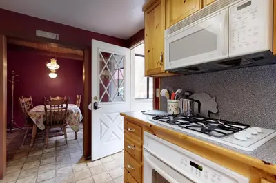a kitchen with a stove top oven next to a table at Foxtail Delight in Dora Belle