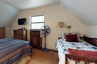 a bedroom with a bed and a fan and a window at Foxtail Delight in Dora Belle
