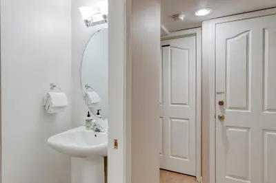 a white bathroom with a sink and a mirror at Hatcher's Hideaway in Shaver Lake