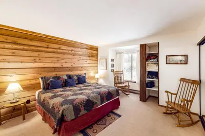 a bedroom with a wooden wall with a bed at Huntington Lake Condo 92 in Lakeshore