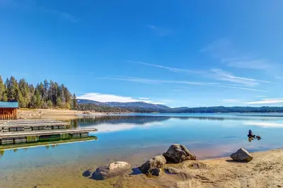 a lake with a dock and a person in the water at Huntington Lake Condo 92 in Lakeshore
