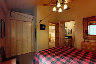 a bedroom with a bed with a checkered blanket at Loggers Landing in Lakeshore