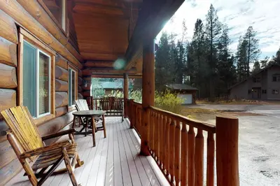 a porch of a log cabin with a table and chairs at Loggers Landing in Lakeshore