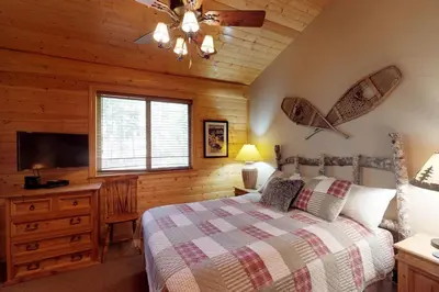 a bedroom with a bed and a flat screen tv at Loggers Landing in Lakeshore
