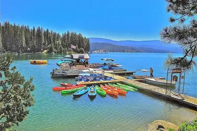 a group of kayaks parked at a dock on a lake at Mountain Memories in Shaver Lake