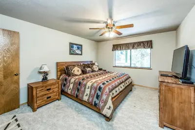a bedroom with a bed and a flat screen tv at Paw's Cabin in Shaver Lake