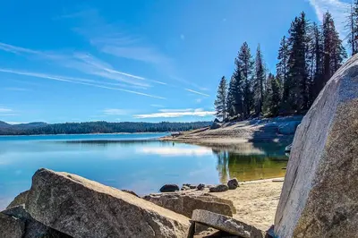 a view of a lake with rocks and trees at Paw's Cabin in Shaver Lake