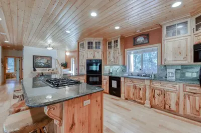 a large kitchen with wooden cabinets and a wooden ceiling at Pinnacle Point in Shaver Lake