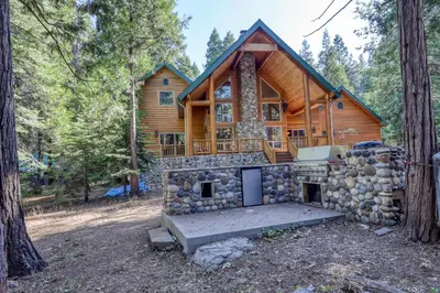 a log cabin in the woods with a stove at Pinnacle Point in Shaver Lake