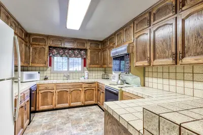 a kitchen with wooden cabinets and a refrigerator at The Limit in Dora Belle