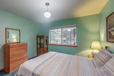 a bedroom with a bed and a dresser and a window at Travelers Rest in Shaver Lake Heights