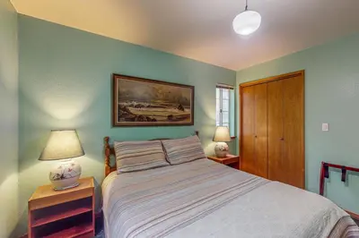 a bedroom with a bed and two night stands with lamps at Travelers Rest in Shaver Lake Heights