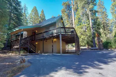 a large house with a large porch and a deck at Travelers Rest in Shaver Lake Heights