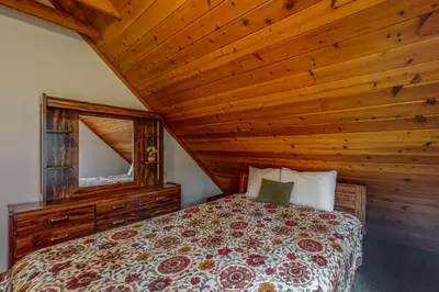 a bedroom with a bed and a wooden ceiling at Travelers Rest in Shaver Lake Heights