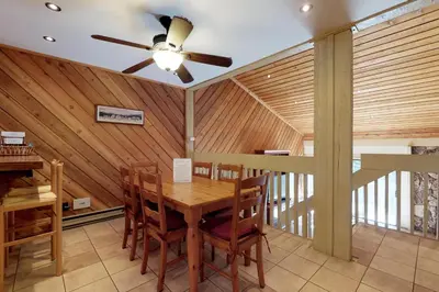 a dining room with a ceiling fan and a wooden table at Blue Jay Condominium in Lakeshore