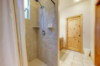 a bathroom with a shower with a glass door at New England Cottage in Shaver Lake