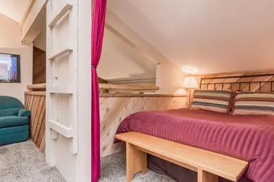 a bedroom with a bed and a bench in a room at Crestview -B # 46 in Mammoth Lakes