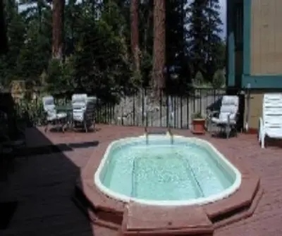 a hot tub in a yard with chairs and a fence at Crestview -B # 46 in Mammoth Lakes